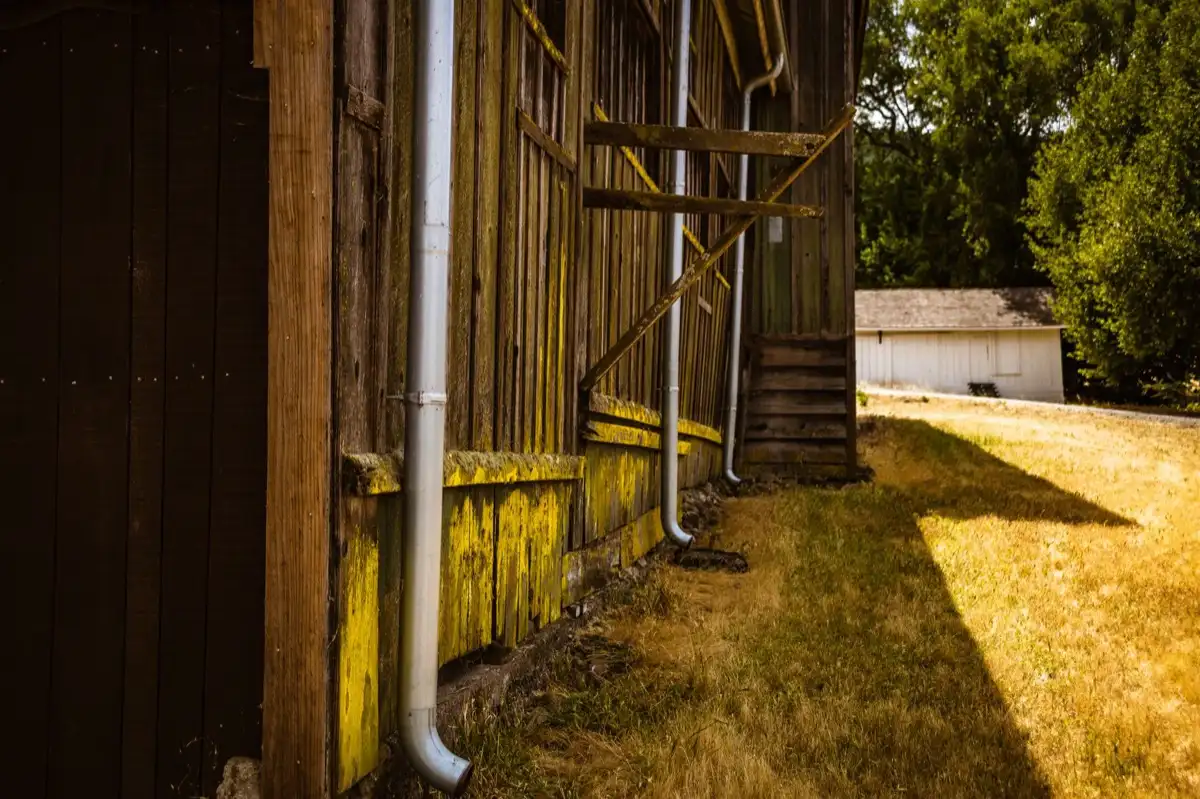 Roof edge, fascia and downspout on a house in Columbia, MO, where drip edge carries runoff into the gutter